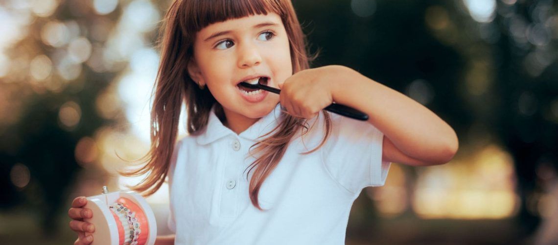 Child with Tooth Model Brushing Teeth