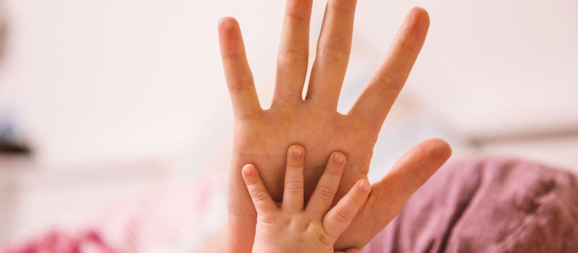 Infant Hand Holding Adult Hand