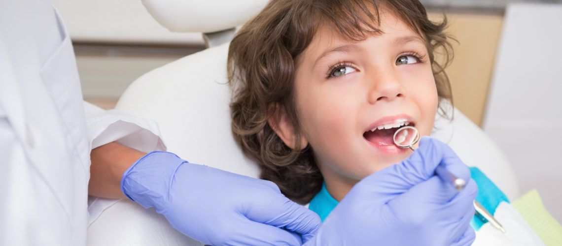Pediatric,Dentist,Examining,A,Little,Boys,Teeth,In,The,Dentists